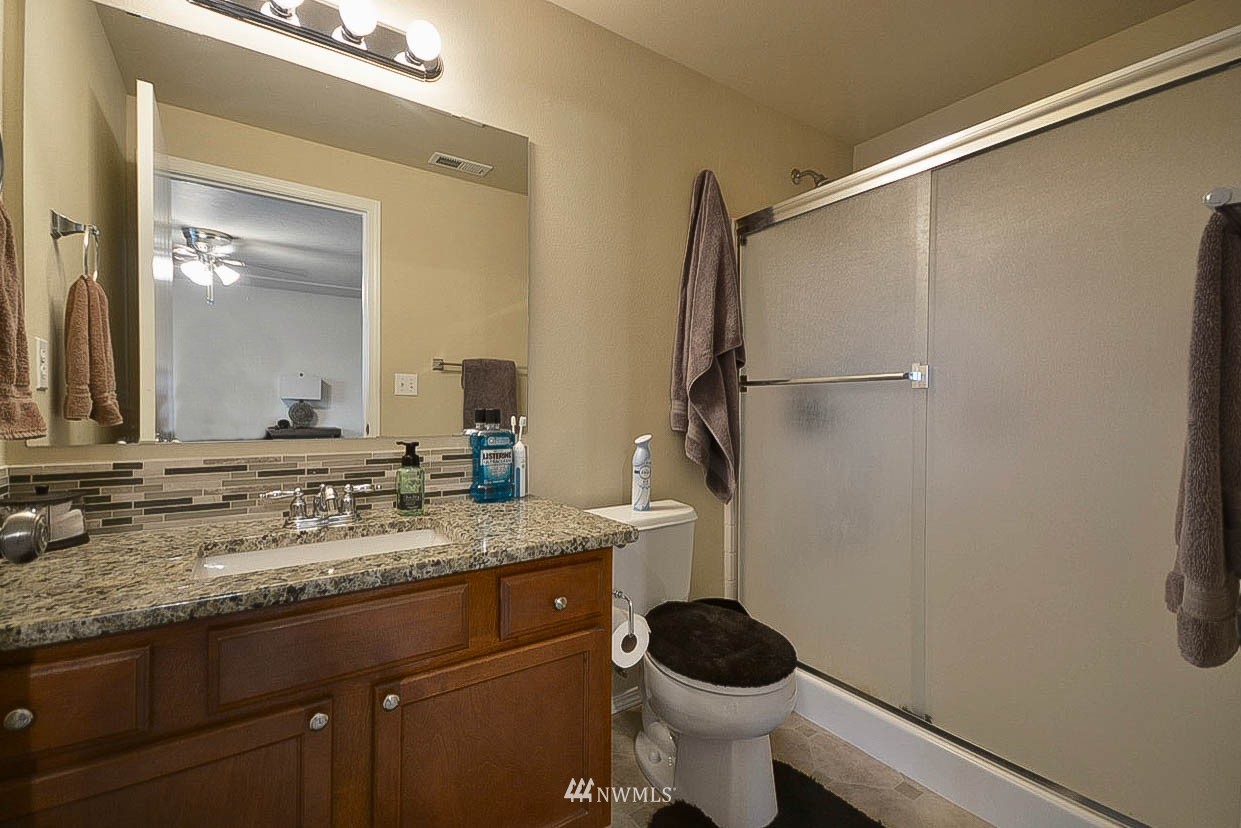 6502 197th Court Southwest Rochester, WA 98579 - Photo 19 of 29 a bathroom with a granite countertop sink toilet and shower