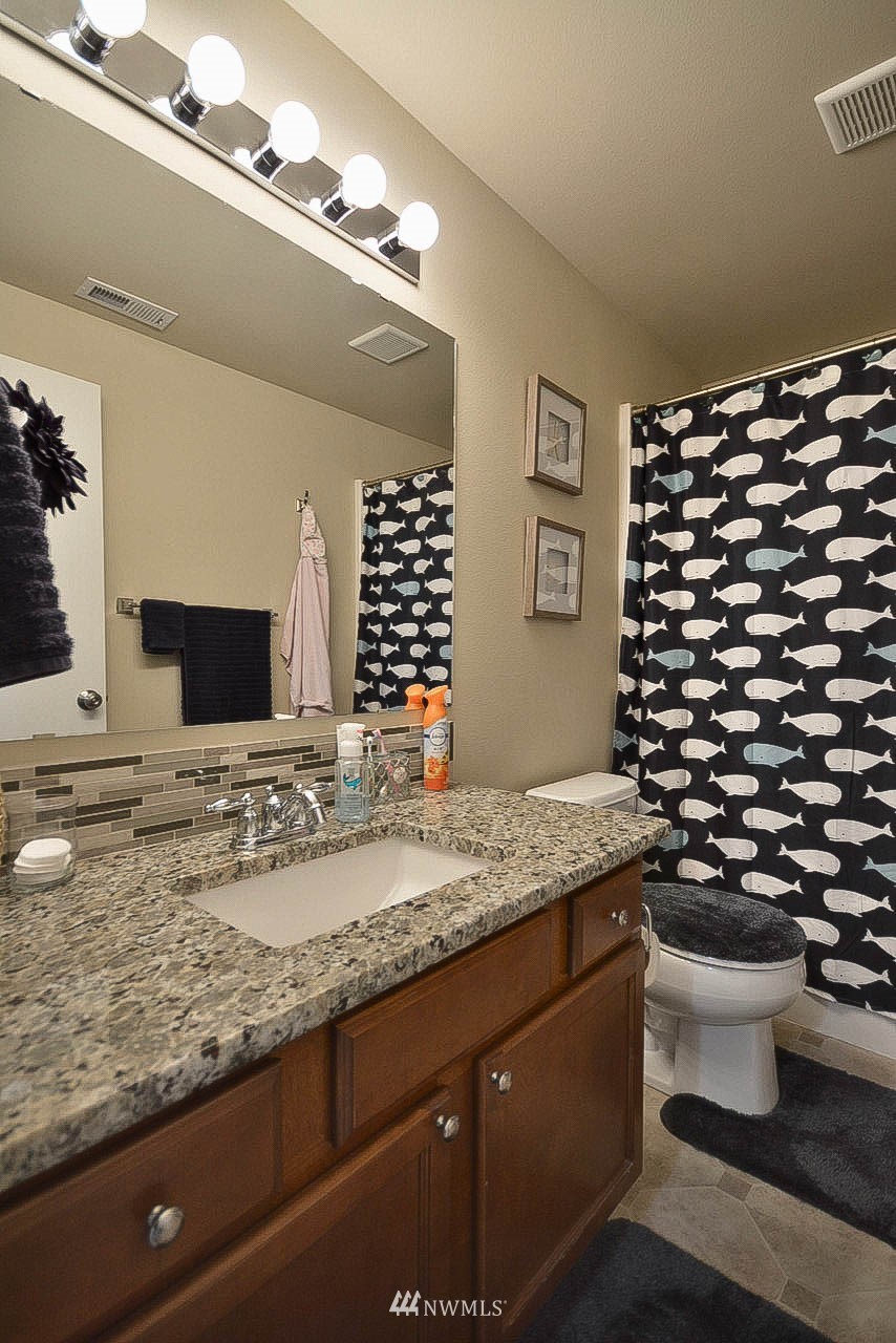 6502 197th Court Southwest Rochester, WA 98579 - Photo 25 of 29 a bathroom with a granite countertop sink toilet and mirror