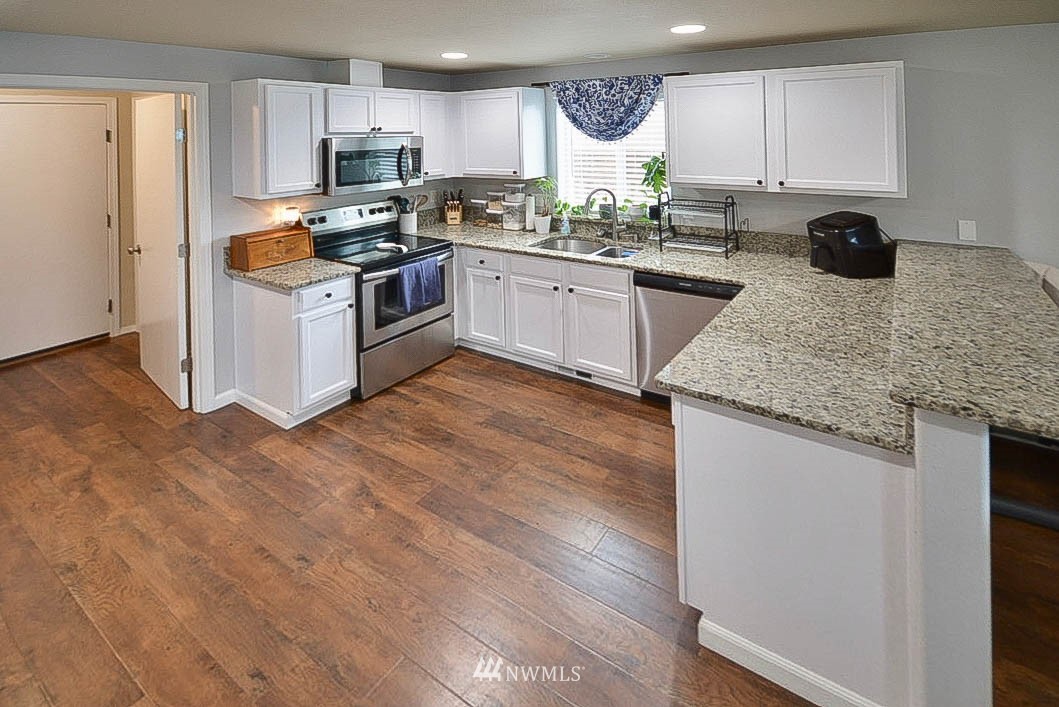 6502 197th Court Southwest Rochester, WA 98579 - Photo 10 of 29 a kitchen with stainless steel appliances granite countertop a stove sink and refrigerator