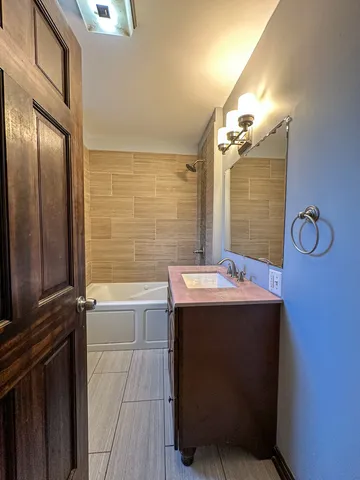 a bathroom with a granite countertop sink a toilet and bathtub