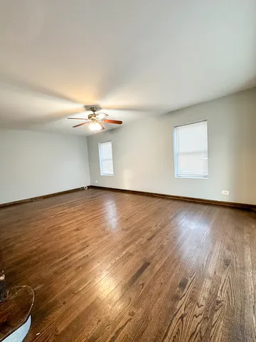 a view of a room with wooden floor and fan