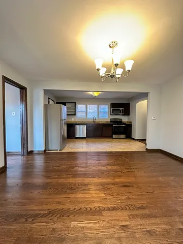 a view of a living room with kitchen and chandelier