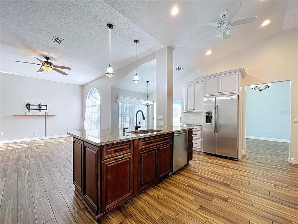 18812 Bascomb Lane Hudson, FL 34667 - Photo 28 of 57 a kitchen with kitchen island granite countertop wooden floors and white cabinets