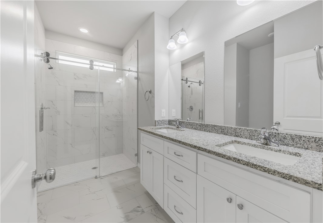 1805 Pin Oak Street Bryan, TX 77803 - Photo 14 of 20 Bathroom with a marble finish shower, double vanity, marble look tile flooring, and recessed lighting