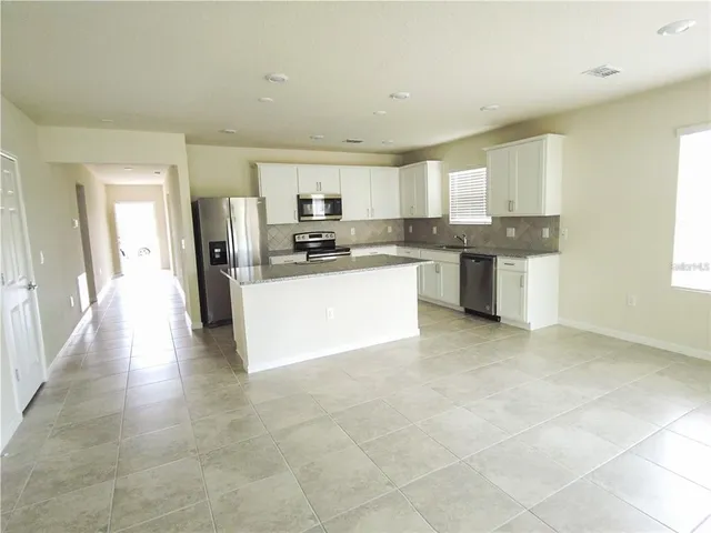 a kitchen with stainless steel appliances a sink a stove a microwave a counter top space and cabinets