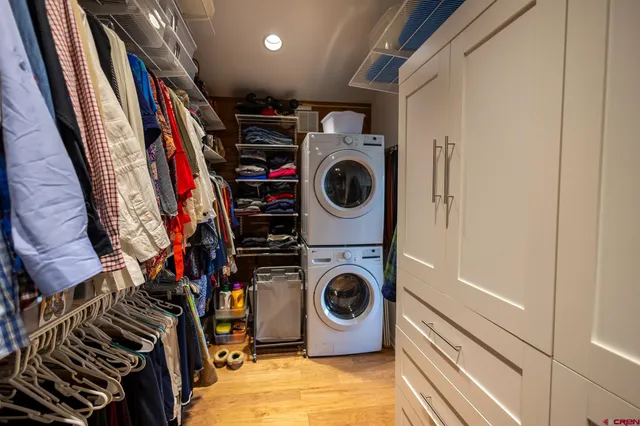a view of walk in closet with clothes and shoes