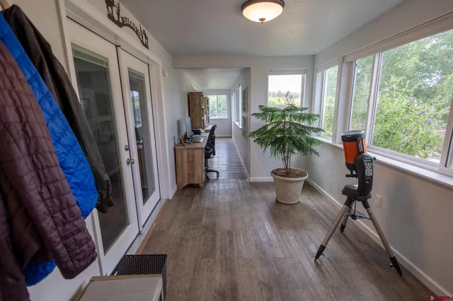 a view of a hallway with wooden floor and windows