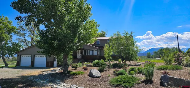 a front view of a house with a yard and a garden