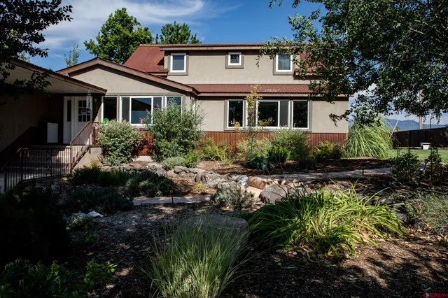 a front view of a house with a yard and potted plants