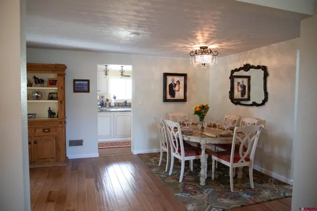 a view of a dining room with furniture wooden floor and chandelier