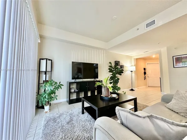a living room with furniture potted plant and a window