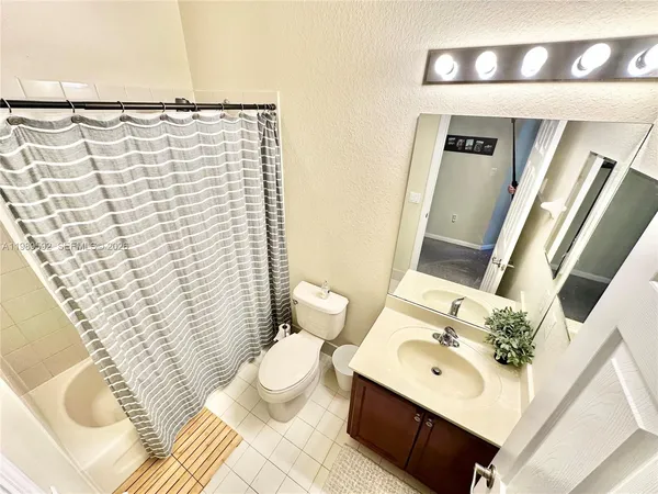 a bathroom with a sink a toilet and shower curtain