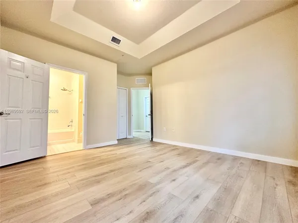 a view of an empty room with wooden floor