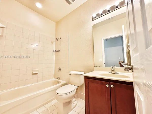 a bathroom with a sink a toilet a mirror and bathtub
