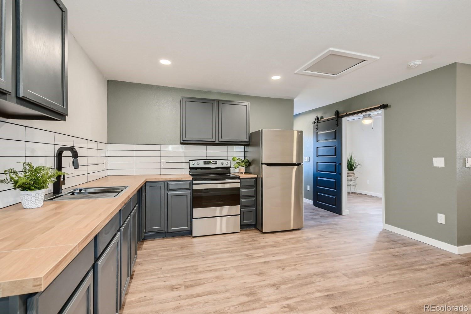 7770 South Kit Carson Drive Centennial, CO 80122 - Photo 19 of 30 a kitchen with stainless steel appliances granite countertop a sink stove and refrigerator