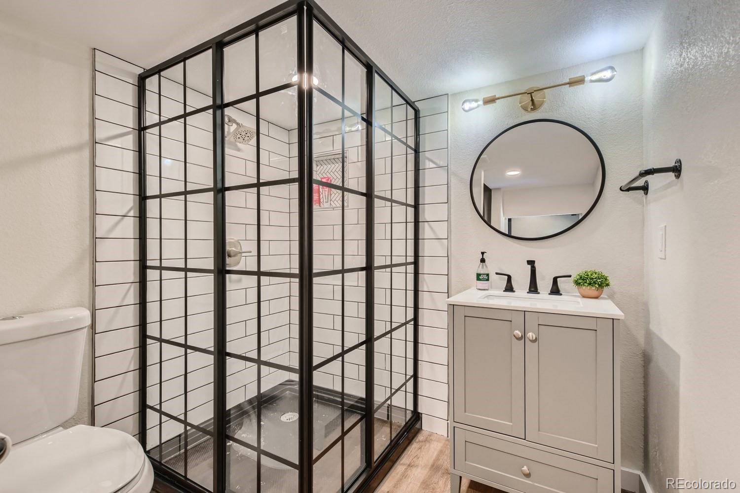 7770 South Kit Carson Drive Centennial, CO 80122 - Photo 23 of 30 a bathroom with a toilet a sink and a mirror