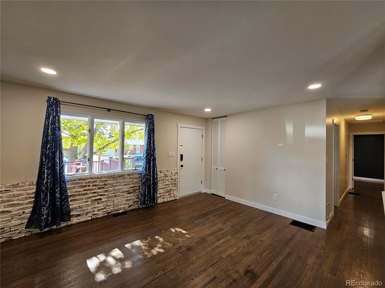7770 South Kit Carson Drive Centennial, CO 80122 - Photo 7 of 30 a view of an empty room with wooden floor and a window