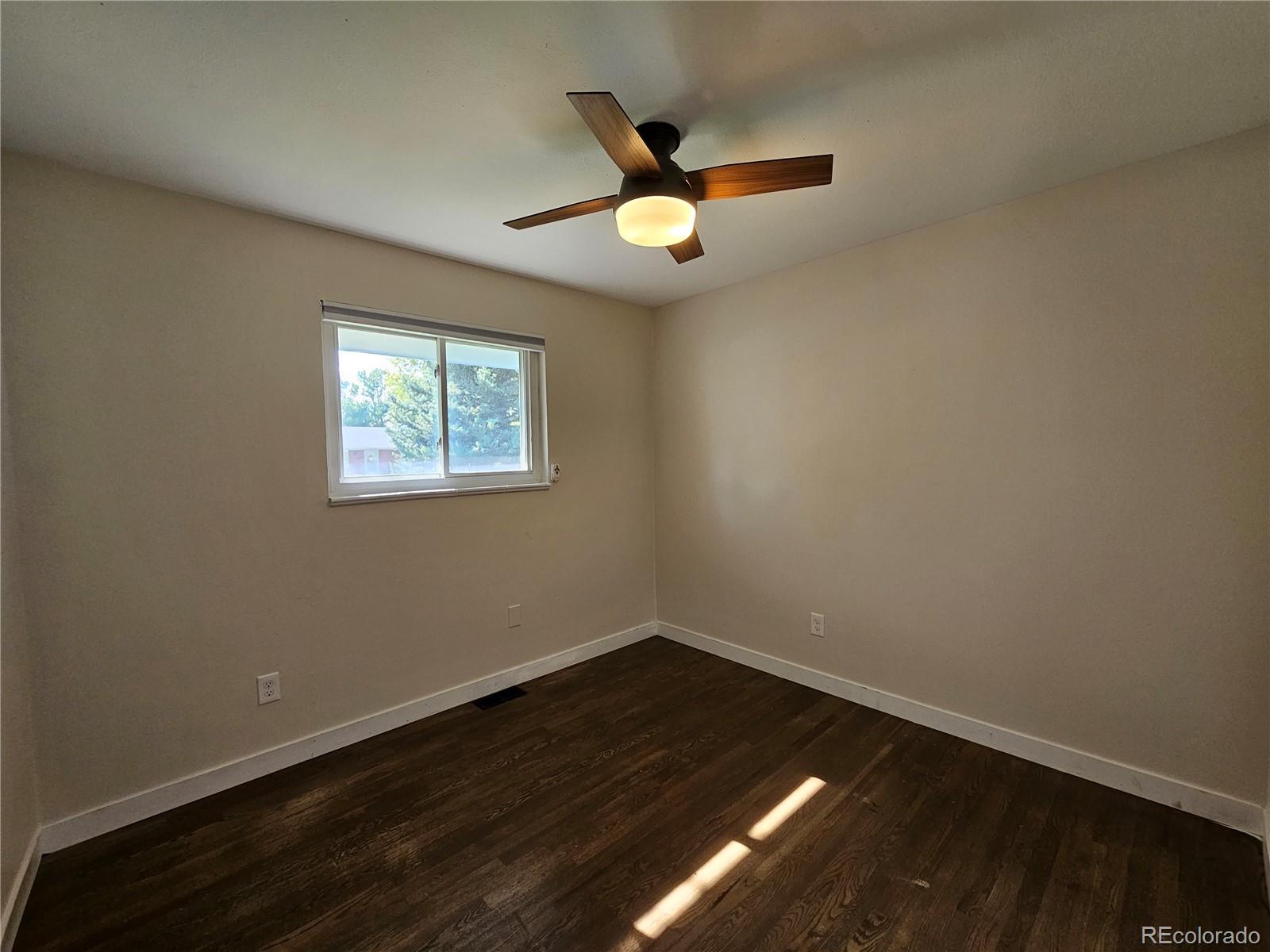 7770 South Kit Carson Drive Centennial, CO 80122 - Photo 10 of 30 an empty room with wooden floor and windows
