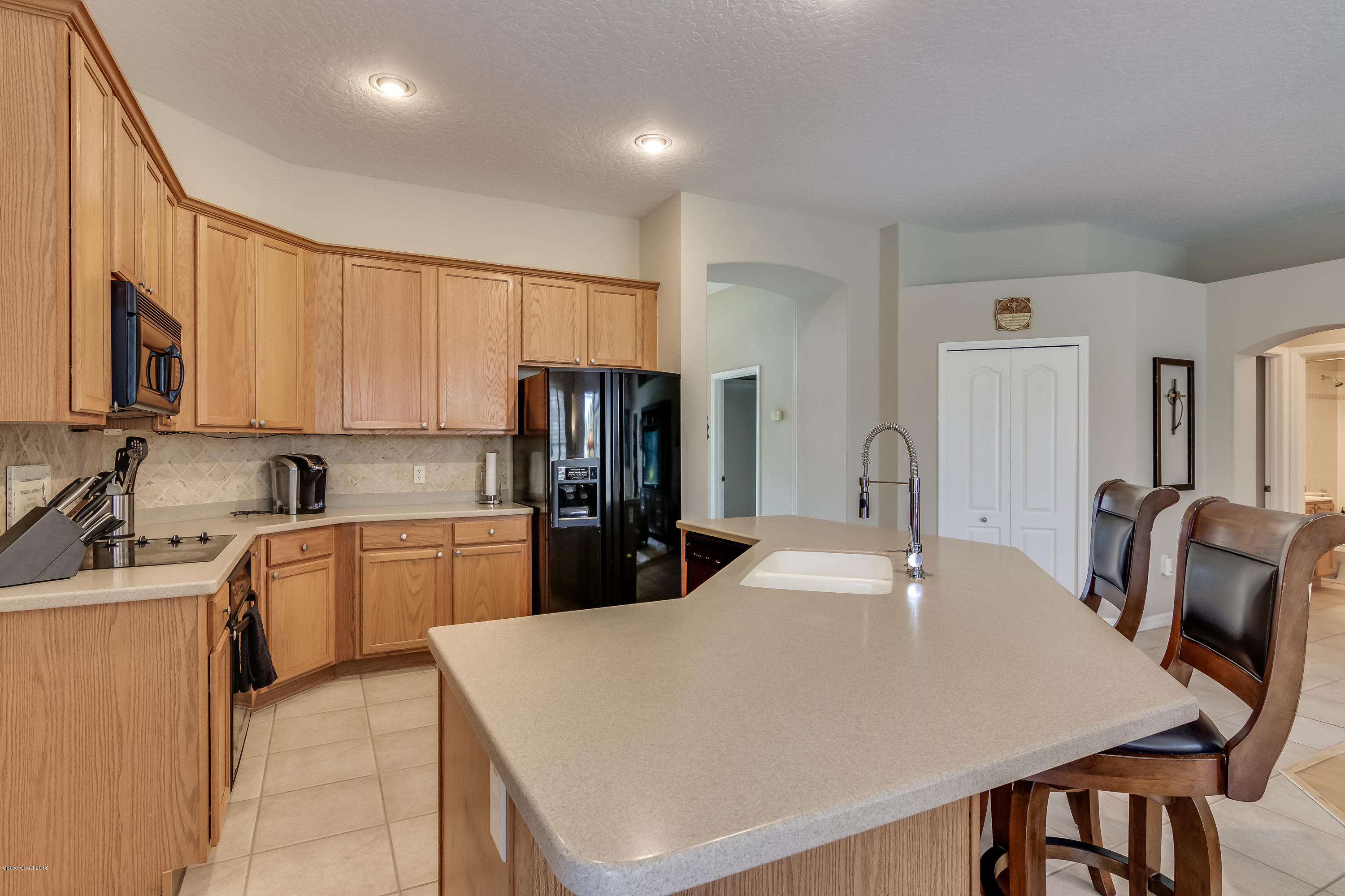 1602 Long Pine Road Melbourne, FL 32940 - Photo 9 of 28 a kitchen with stainless steel appliances granite countertop a refrigerator a sink a stove a dining table and chairs
