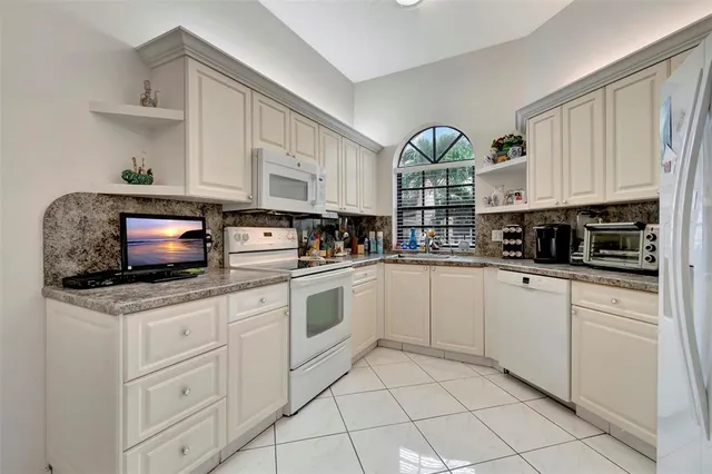 a kitchen with stainless steel appliances white cabinets and a refrigerator