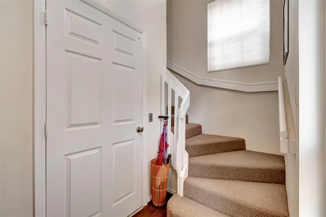 a view of staircase with lots of frames on wall and a window
