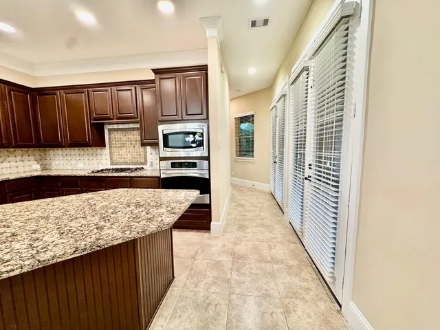 a kitchen with kitchen island granite countertop wooden cabinets a sink and dishwasher