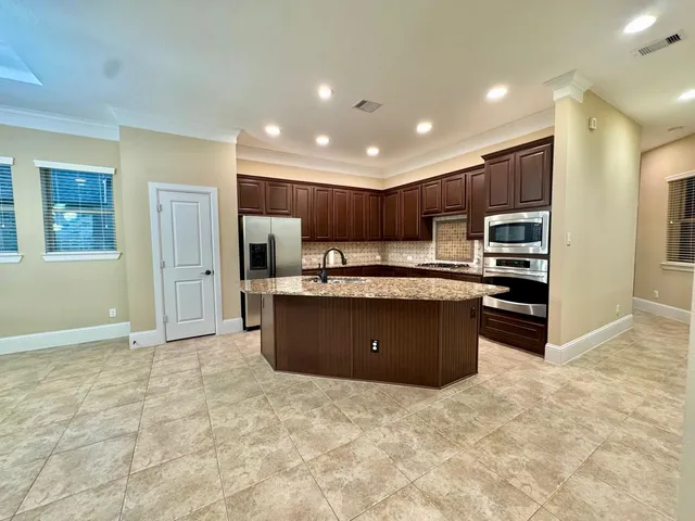 a kitchen with stainless steel appliances granite countertop a refrigerator and a sink