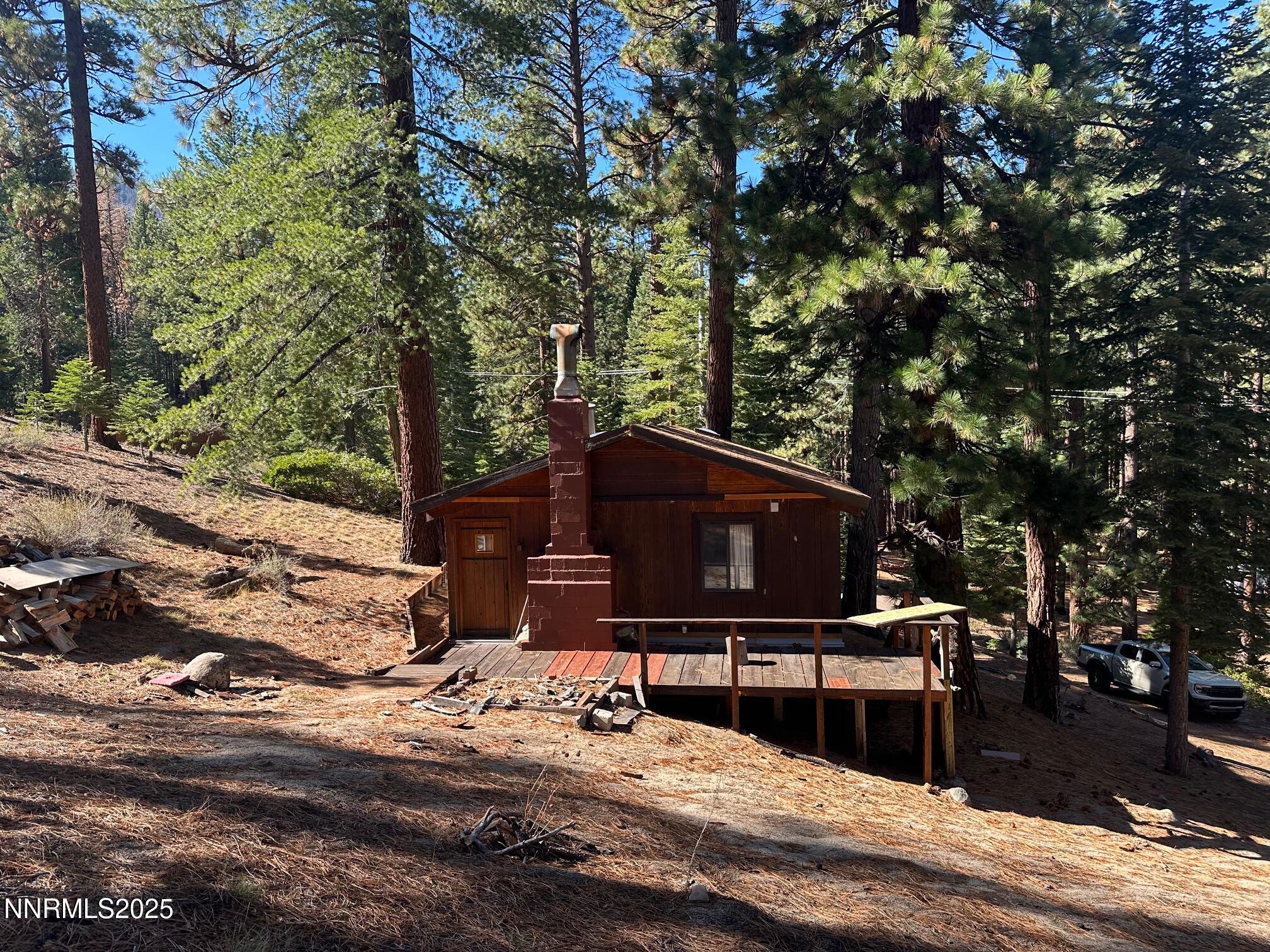 201 Shay Creek Road Markleeville, CA 96120 - Photo 6 of 35 a living room with a fireplace and a flat screen tv