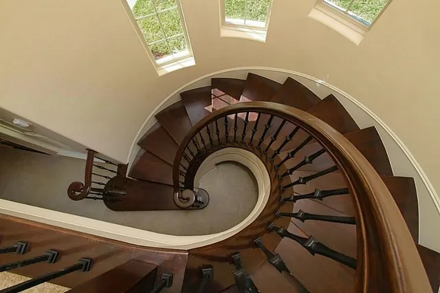a view of empty room with a chandelier fan and kitchen view