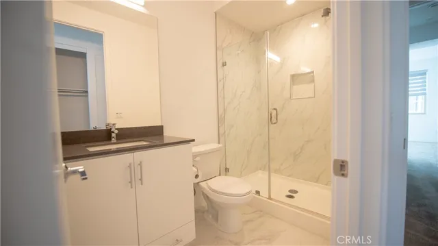 a bathroom with a granite countertop sink a toilet and shower
