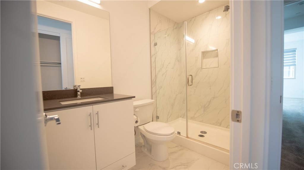 339 Placemark Irvine, CA 92614 - Photo 11 of 30 a bathroom with a granite countertop sink a toilet and shower