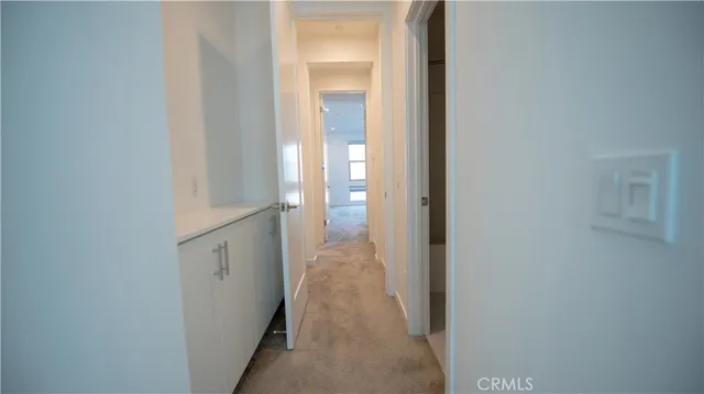 a view of a hallway with wooden floor and closet