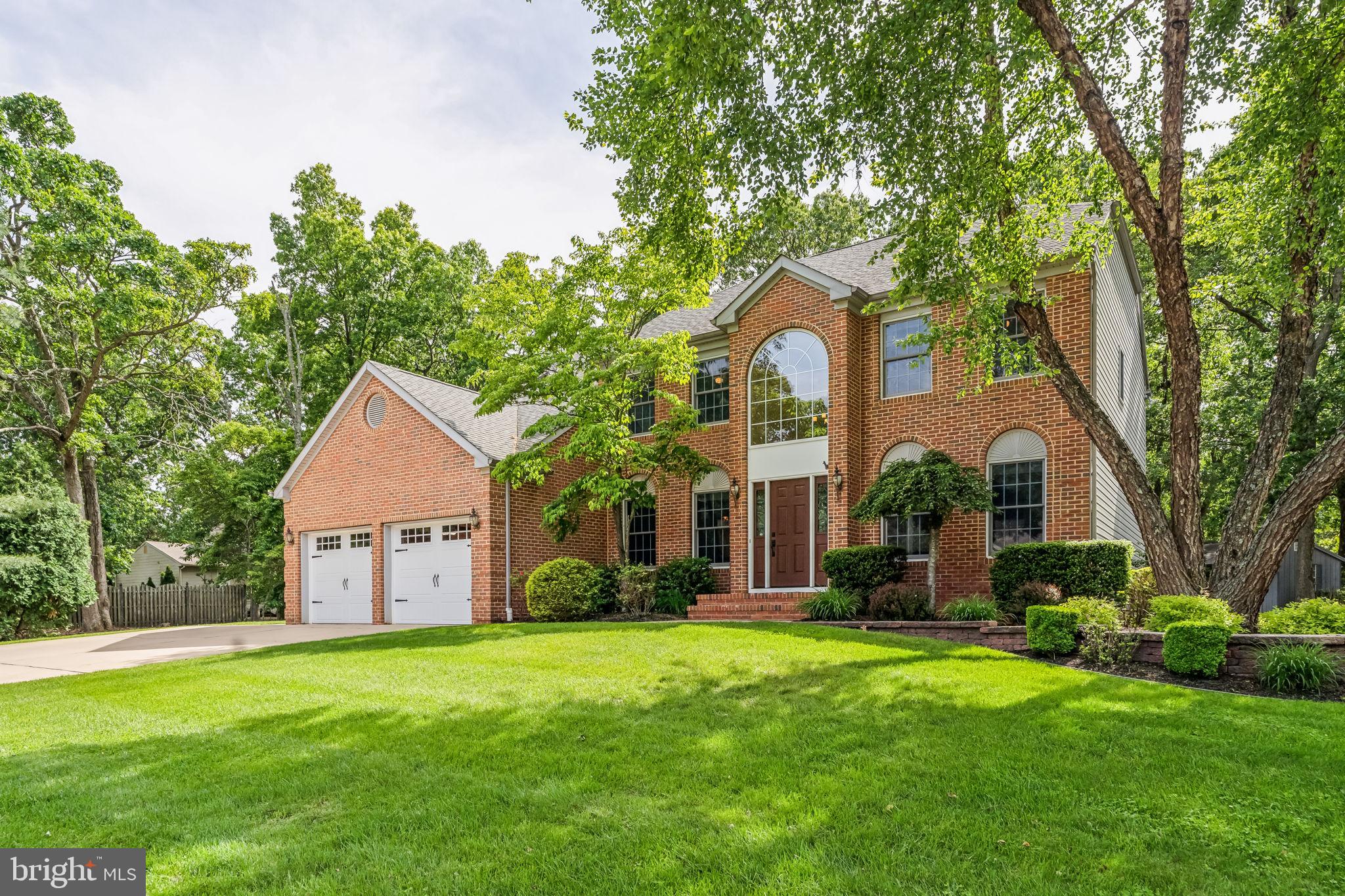a front view of a house with a yard and trees