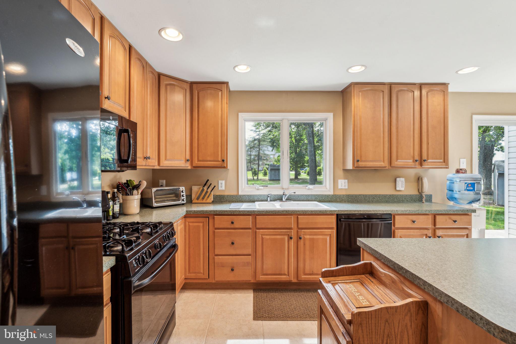 22 Devonshire Drive Voorhees, NJ 08043 - Photo 26 of 54 a kitchen with stainless steel appliances granite countertop a stove top oven a sink dishwasher a dining table and chairs with wooden floor
