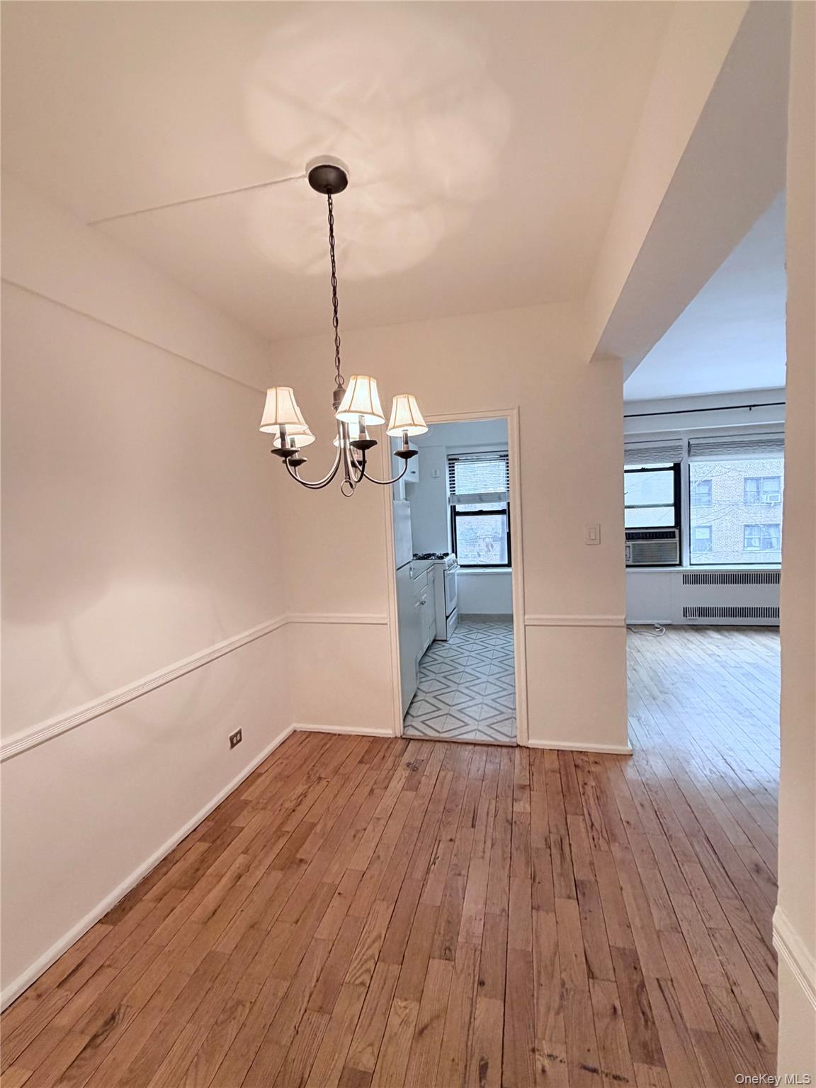 99-21 67th Road, Unit 3A Queens, NY 11375 - Photo 5 of 18 Unfurnished dining area with light wood-style floors and suspended lighting