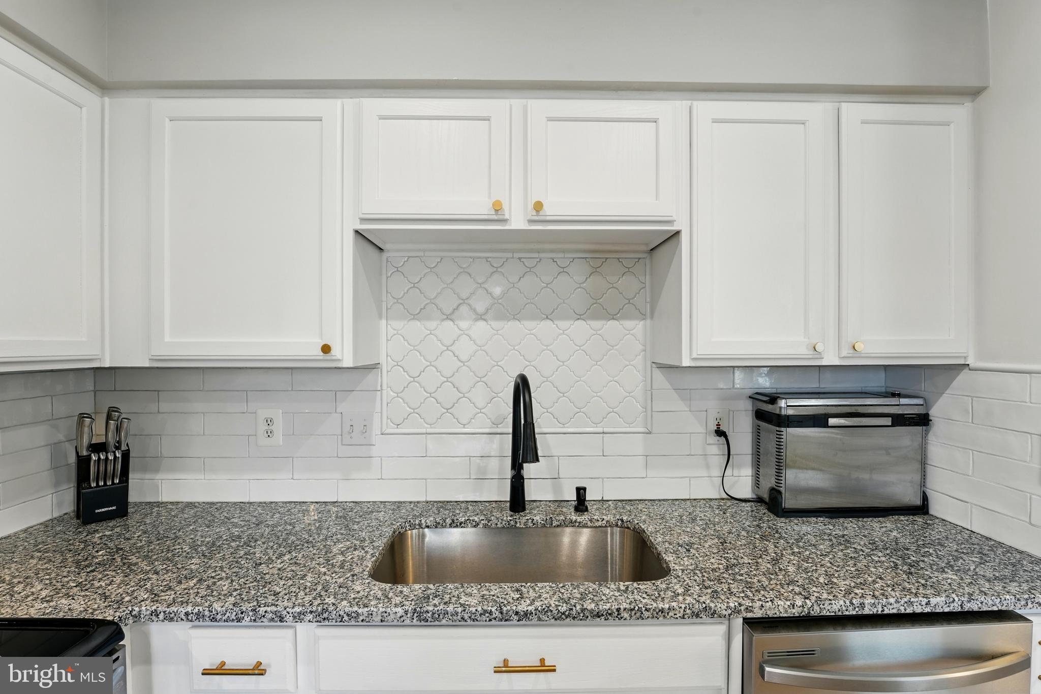 7045 Sauvage Lane Gainesville, VA 20155 - Photo 18 of 43 a kitchen with granite countertop a sink and a stove