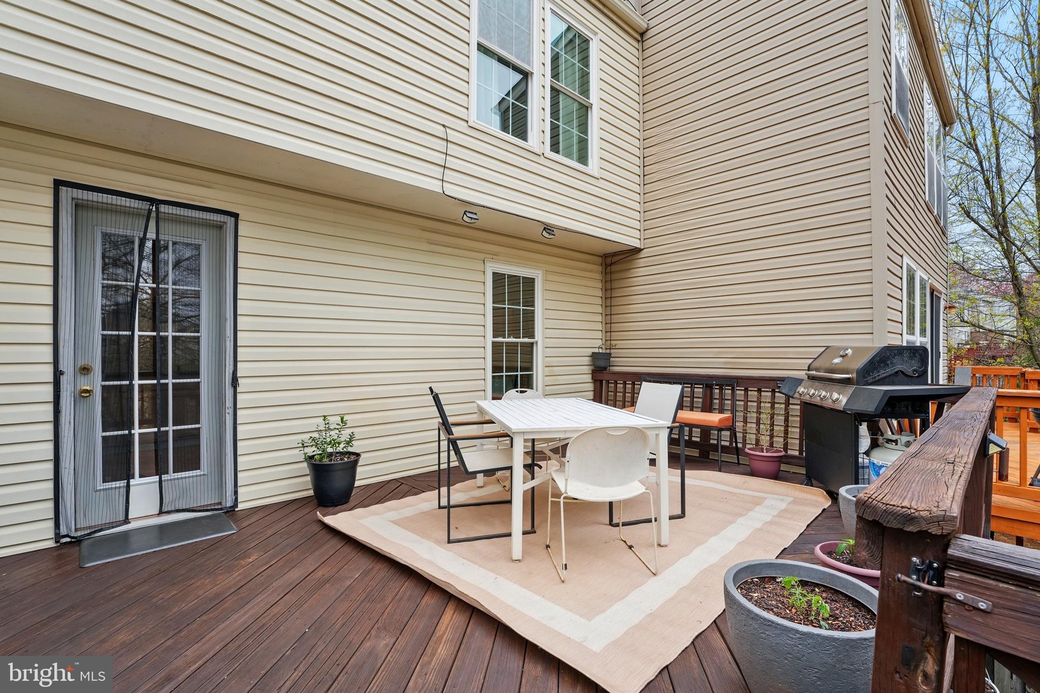 7045 Sauvage Lane Gainesville, VA 20155 - Photo 22 of 43 a view of a dinning table and chairs in wooden deck