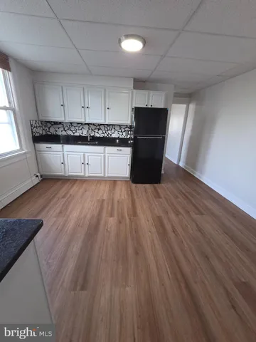 a large kitchen with cabinets wooden floor and stainless steel appliances