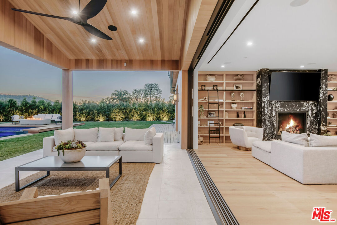 5505 Hoback Glen Road Hidden Hills, CA 91302 - Photo 3 of 43 a living room with fireplace furniture and a floor to ceiling window