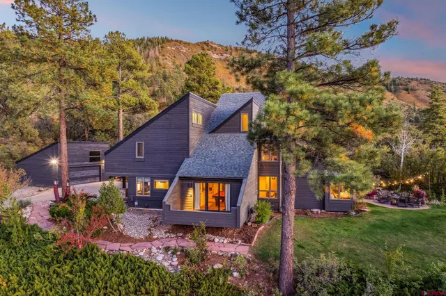 a aerial view of a house with a yard and large tree