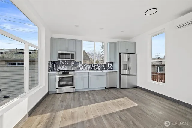 a kitchen with white cabinets and stainless steel appliances