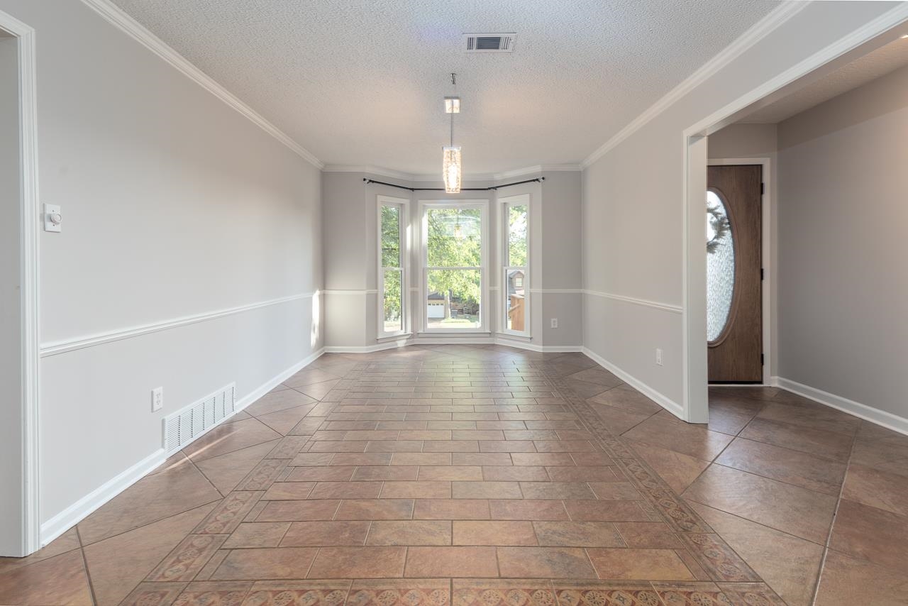 8364 Bazemore Road Cordova, TN 38018 - Photo 20 of 33 an empty room with floor to ceiling windows and chandelier
