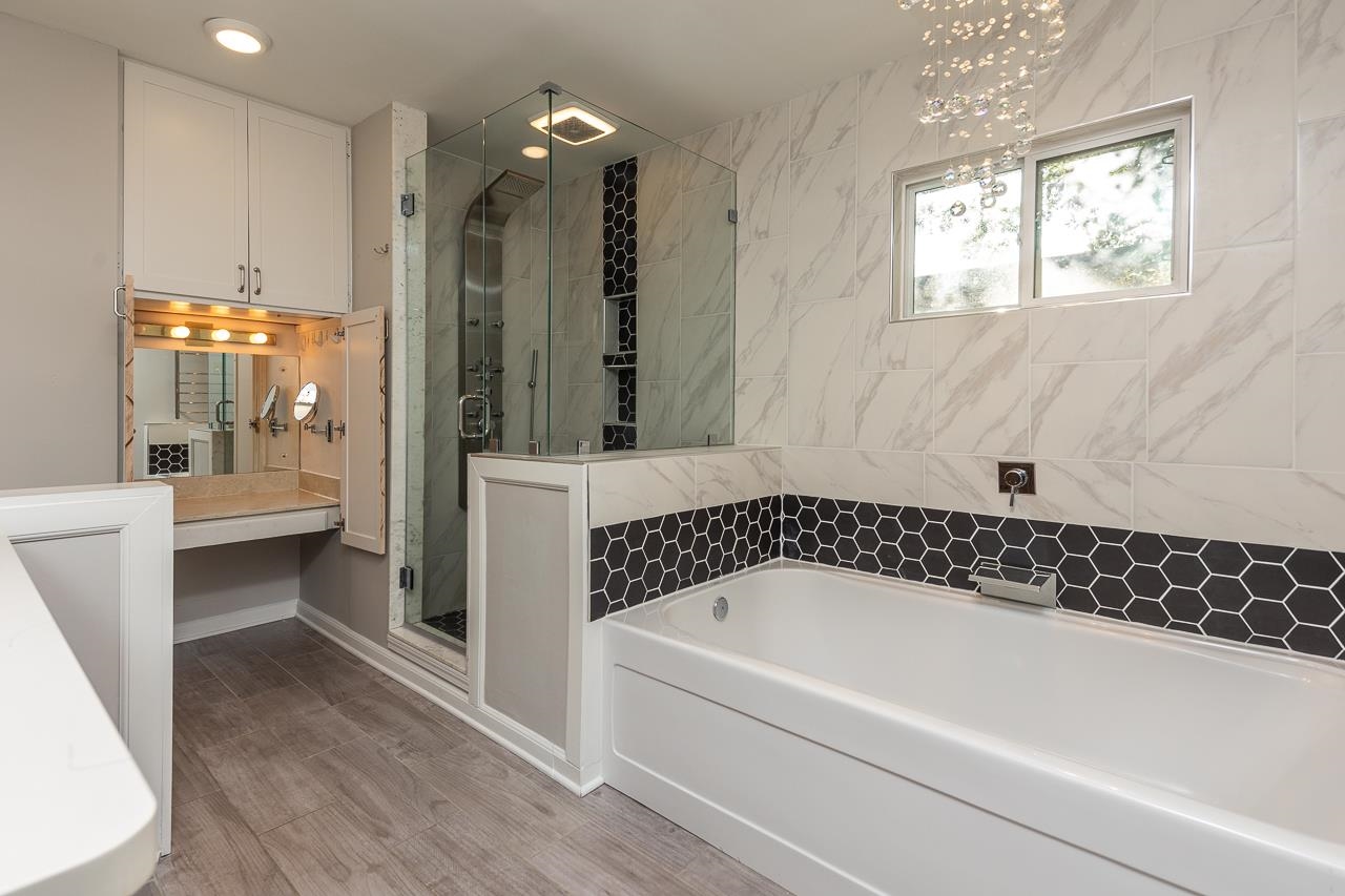 8364 Bazemore Road Cordova, TN 38018 - Photo 24 of 33 a bathroom with a bathtub a mirror a sink and shower
