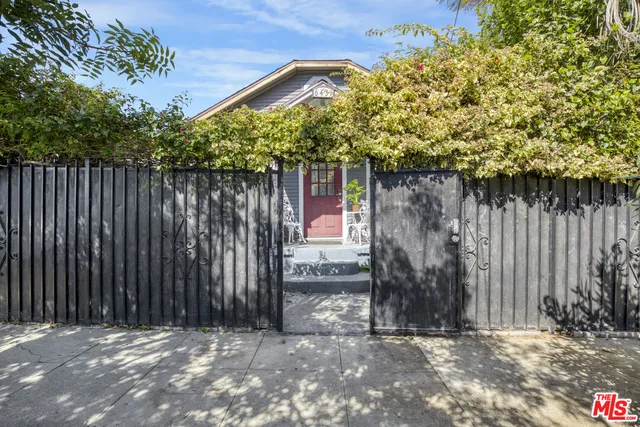 a backyard of a house with lawn chairs and wooden fence
