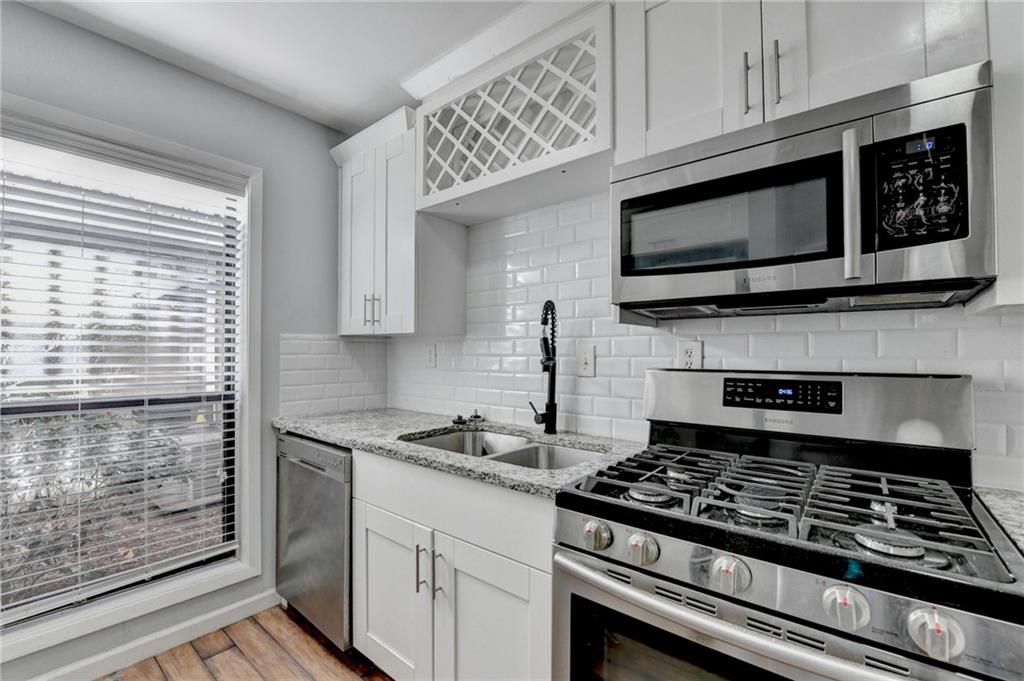 516 Wynnes Ridge Circle Southeast, Unit 516 Marietta, GA 30067 - Photo 19 of 40 a kitchen with stainless steel appliances granite countertop a stove microwave and cabinets