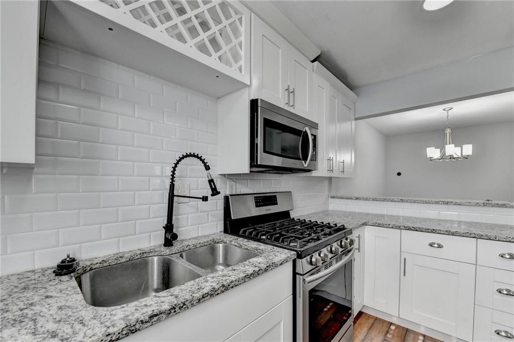 516 Wynnes Ridge Circle Southeast, Unit 516 Marietta, GA 30067 - Photo 20 of 40 a kitchen with granite countertop a sink stainless steel appliances and cabinets