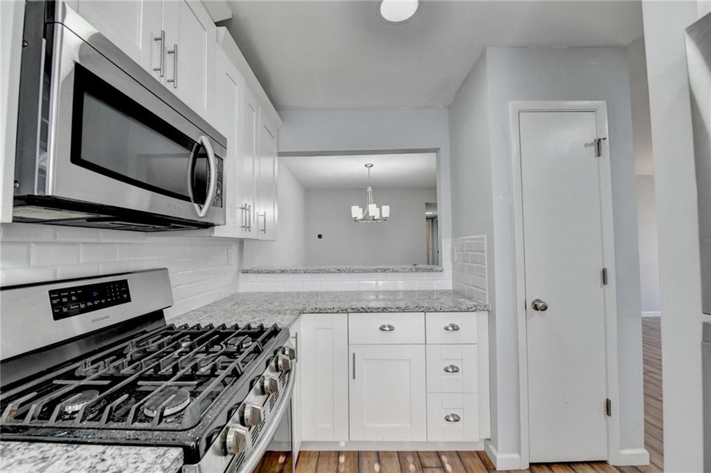 516 Wynnes Ridge Circle Southeast, Unit 516 Marietta, GA 30067 - Photo 21 of 40 a kitchen with granite countertop a stove and a microwave