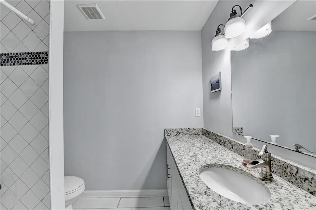 516 Wynnes Ridge Circle Southeast, Unit 516 Marietta, GA 30067 - Photo 29 of 40 a bathroom with a granite countertop sink a mirror and shower
