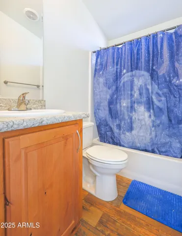 a bathroom with a granite countertop sink and a toilet