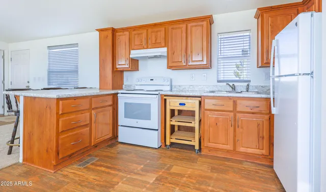 a kitchen with granite countertop a sink and cabinets